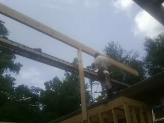 Carpenter setting a ridge beam over a new addition frame — Ice Dam Removal by Roofing Brothers in Monetta