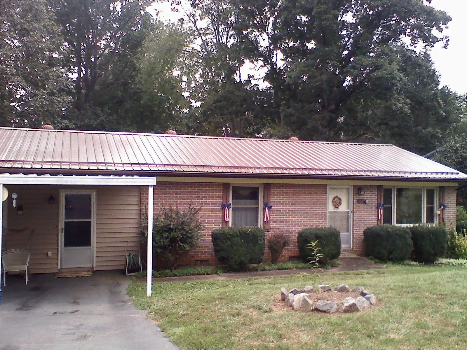 Bronze metal roof and carport on a brick ranch home — Roof Repair work by our crew in Monetta